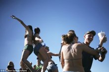 Drinking: Young women and men drink and dance on their four-wheel drive vehicles at the Redneck Yacht Club (stock photo)
